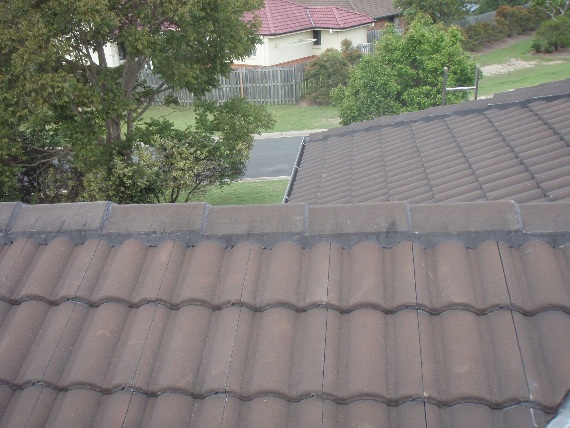 Two Men Are Working On The Roof Of A House — Gold Coast Roof Repairs in Mudgeeraba, QLD