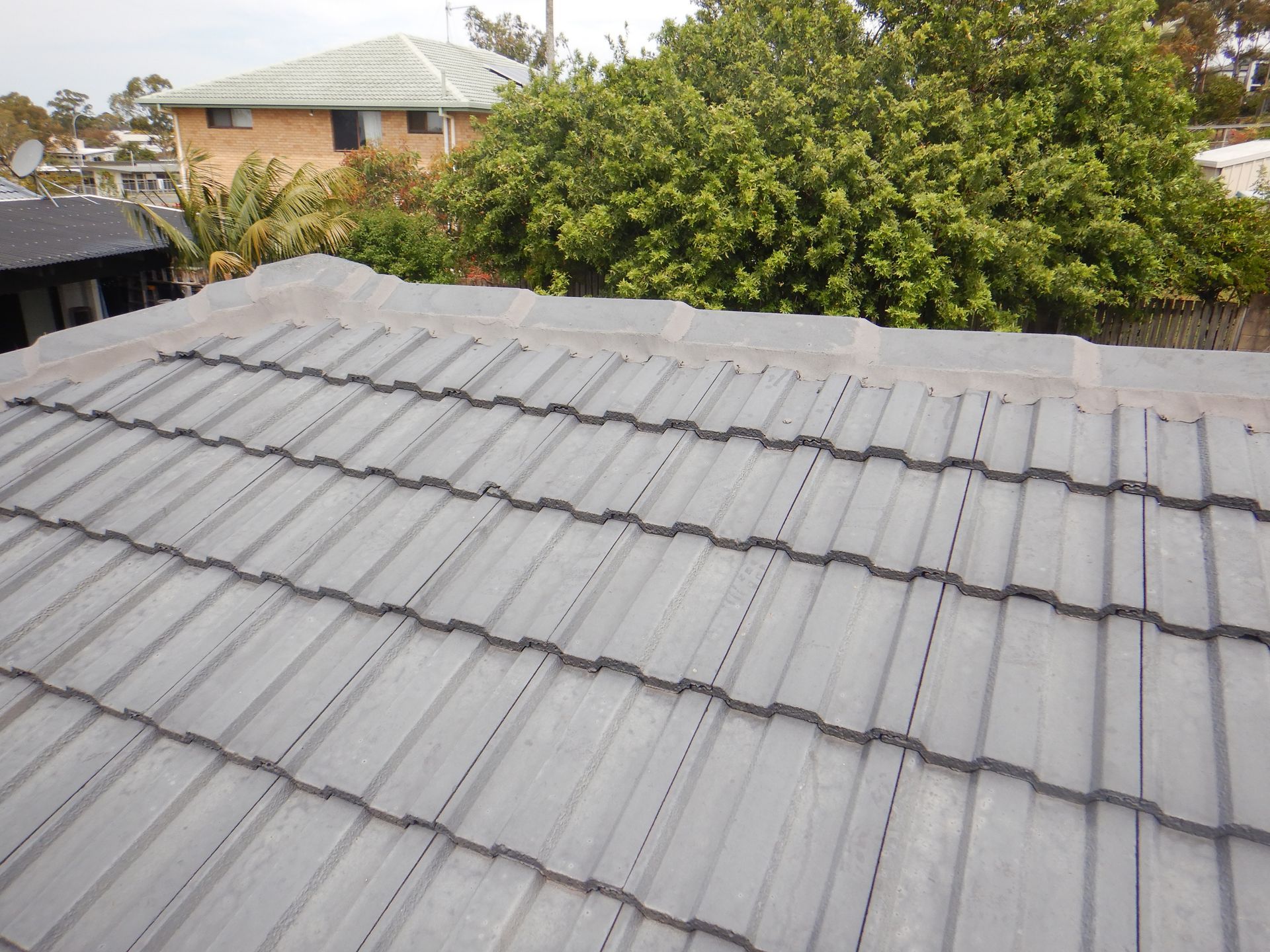 A Man In Red Pants Is Working On A Roof — Gold Coast Roof Repairs in Burleigh Heads, QLD