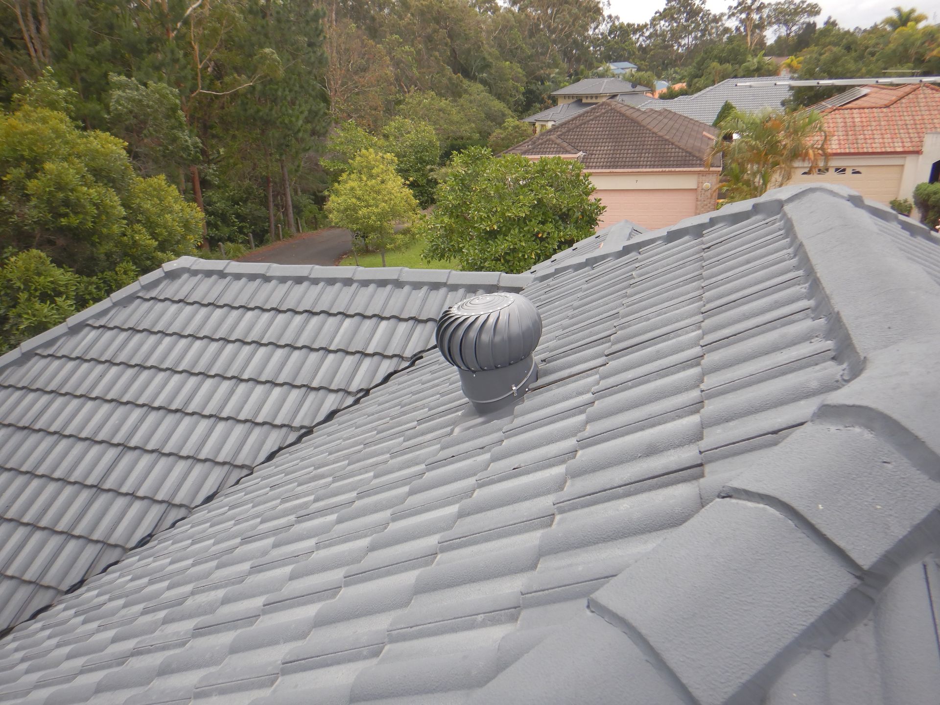 A Bucket Of Cement Is Sitting On A Roof Next To A Shovel — Gold Coast Roof Repairs in Mudgeeraba, QLD