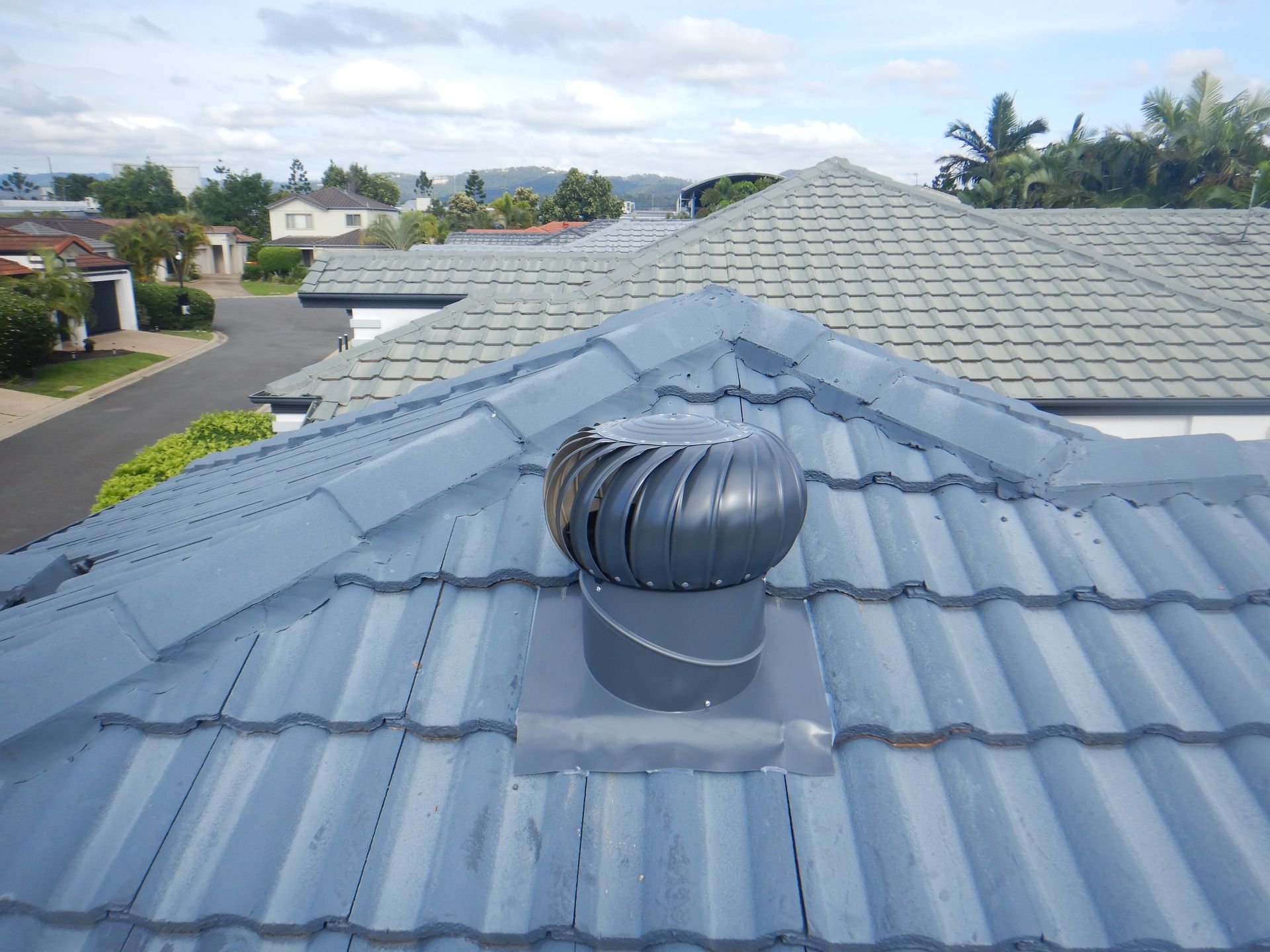 The Roof Of A House With A Wind Turbine On It — Gold Coast Roof Repairs in Ormeau, QLD