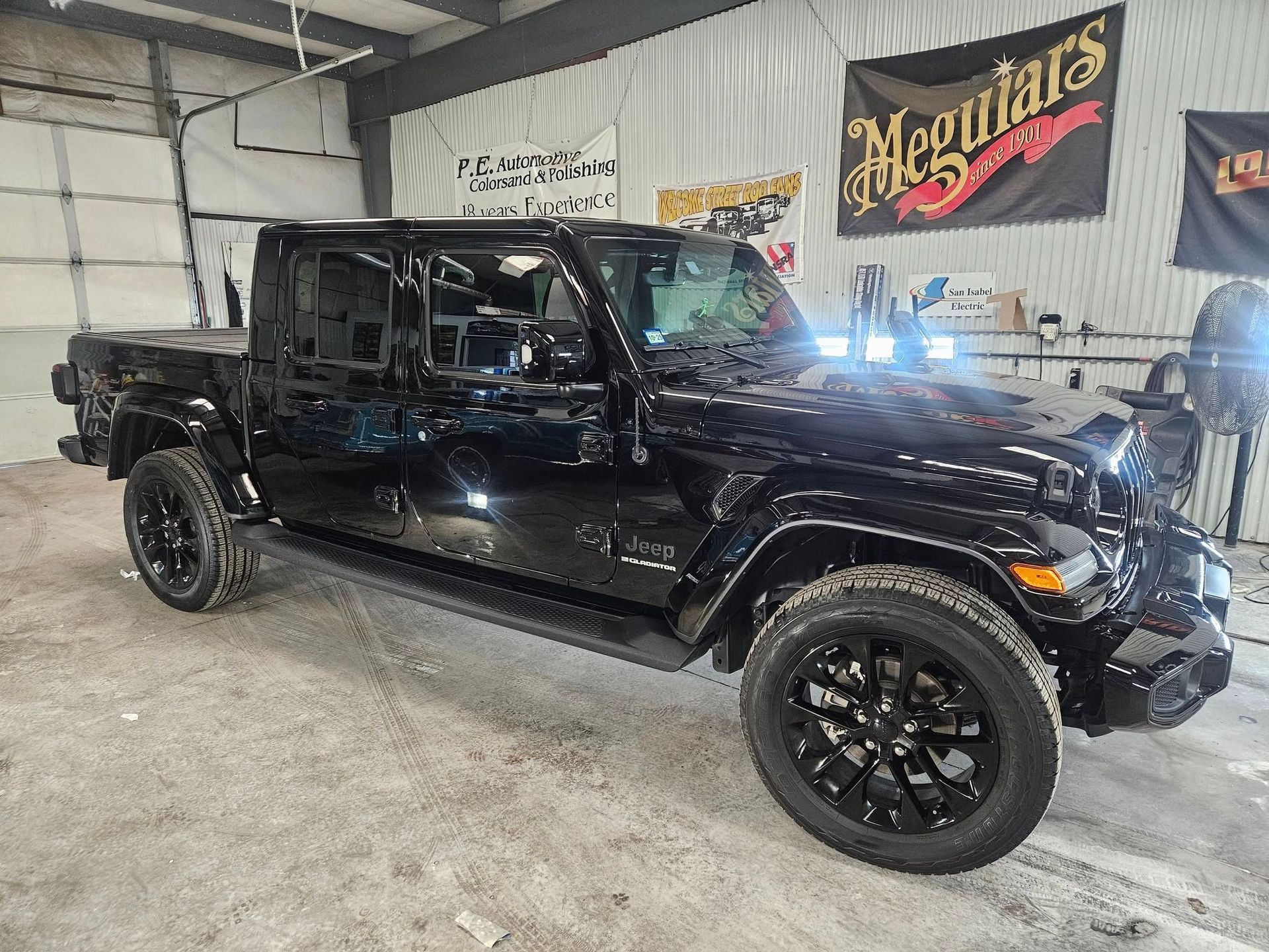 Black Jeep Gladiator truck parked inside a garage.