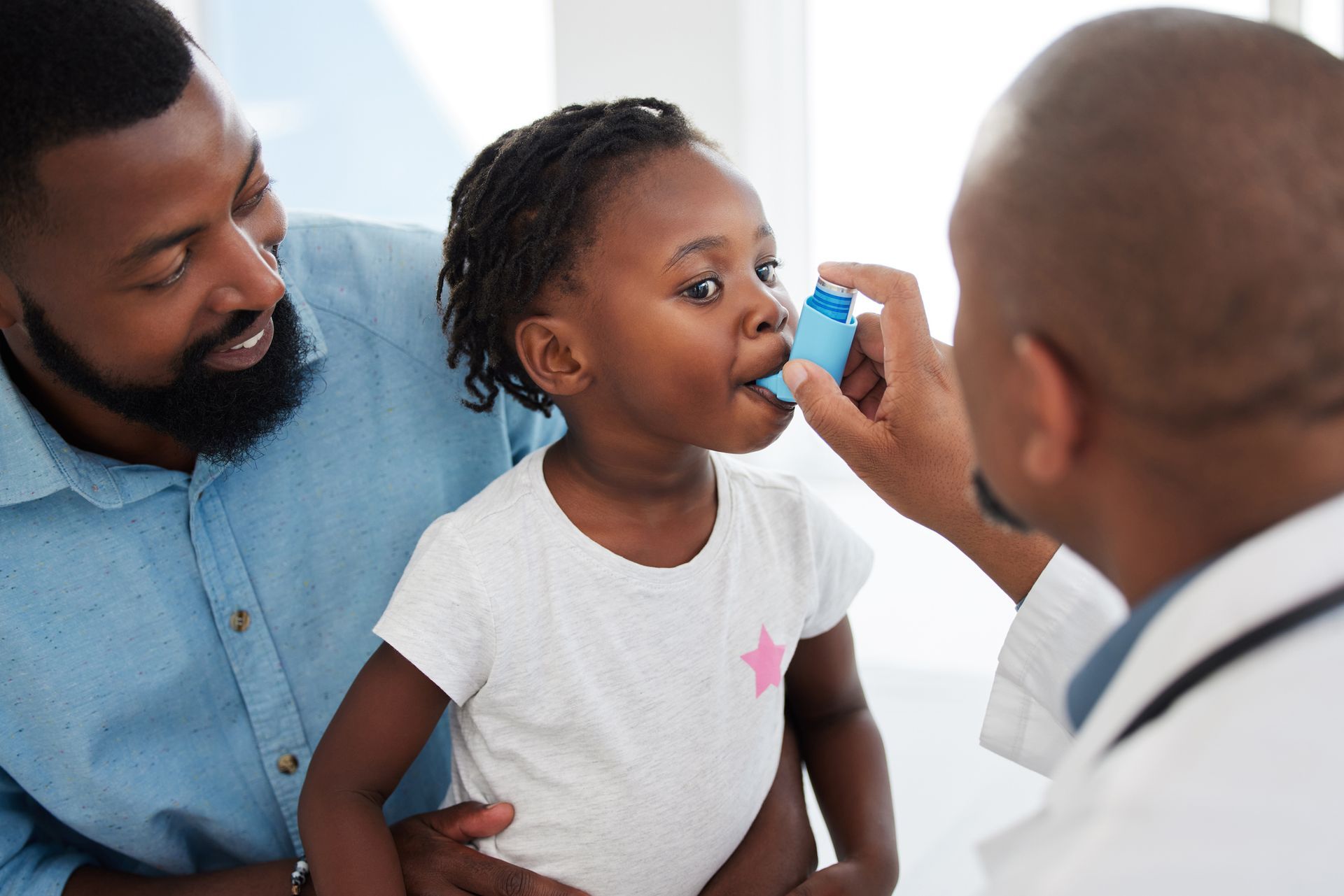 A little girl is getting an inhaler from a doctor.