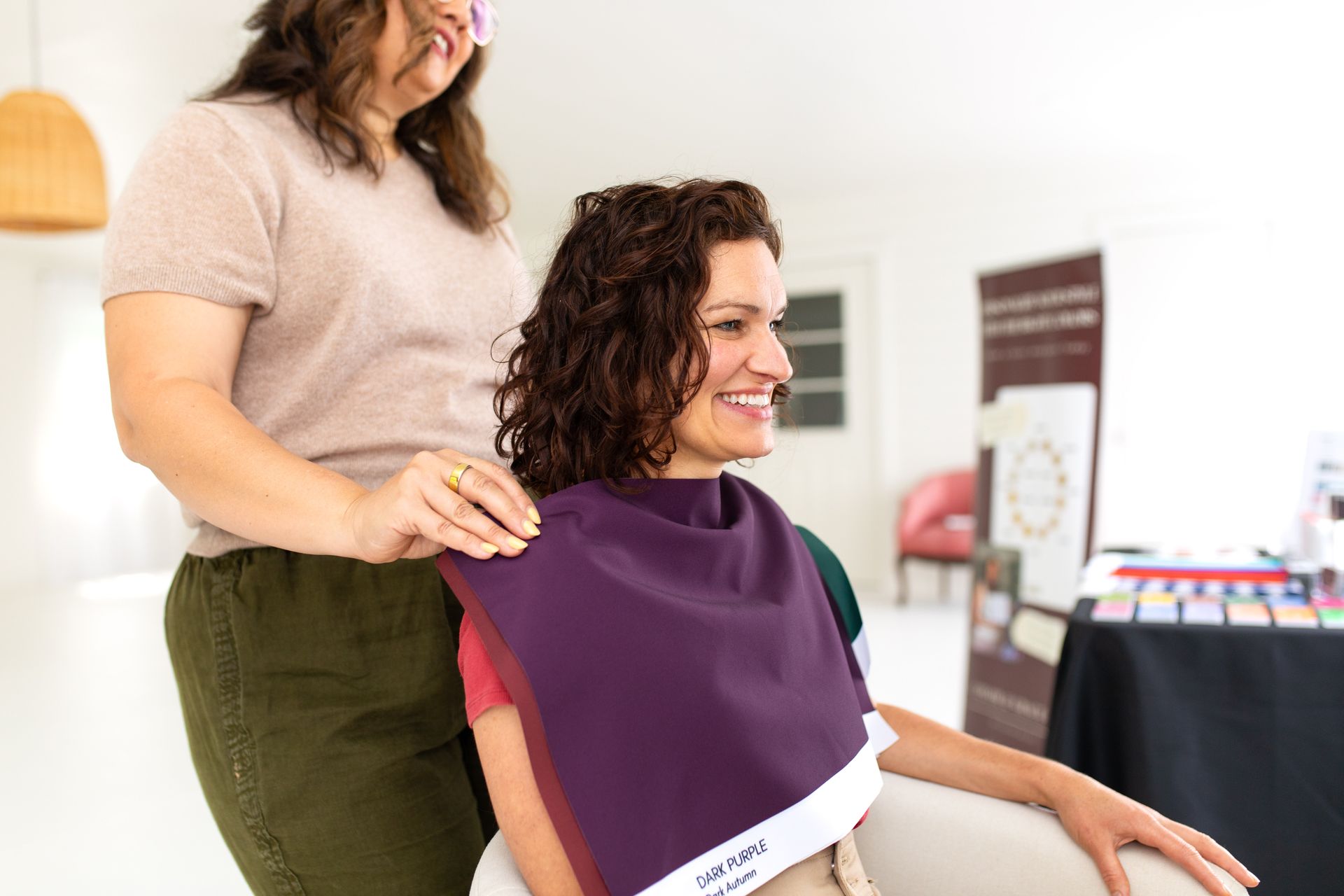 Woman getting a haircut with a purple cape at a salon