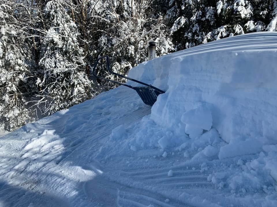 Une pelle est posée sur un tas de neige.