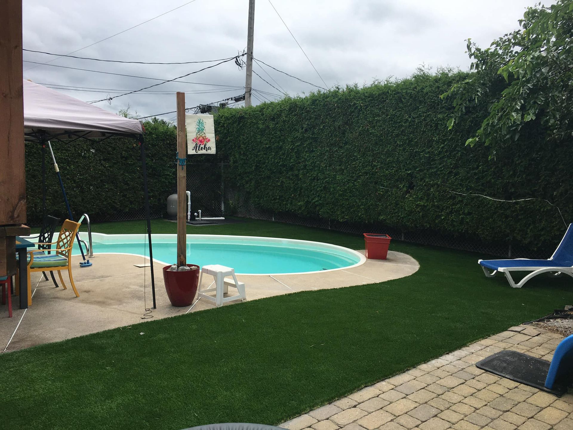 Une cour avec une piscine et des chaises de jardin