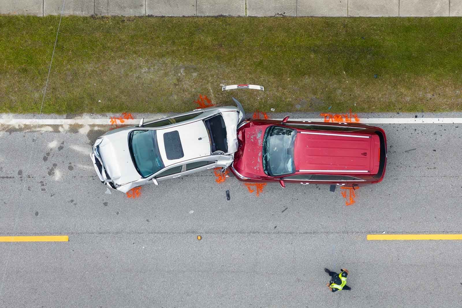 An aerial view of a car accident on the side of the road.