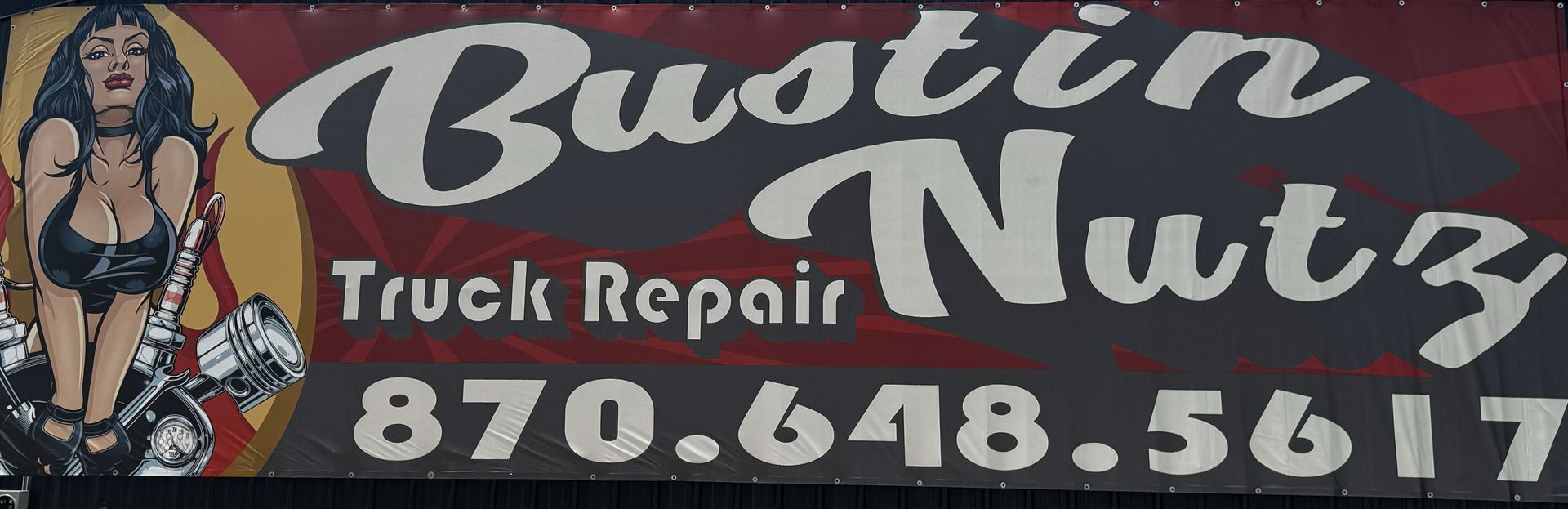 A sign for bustin nuts truck repair shows a woman on a motorcycle
