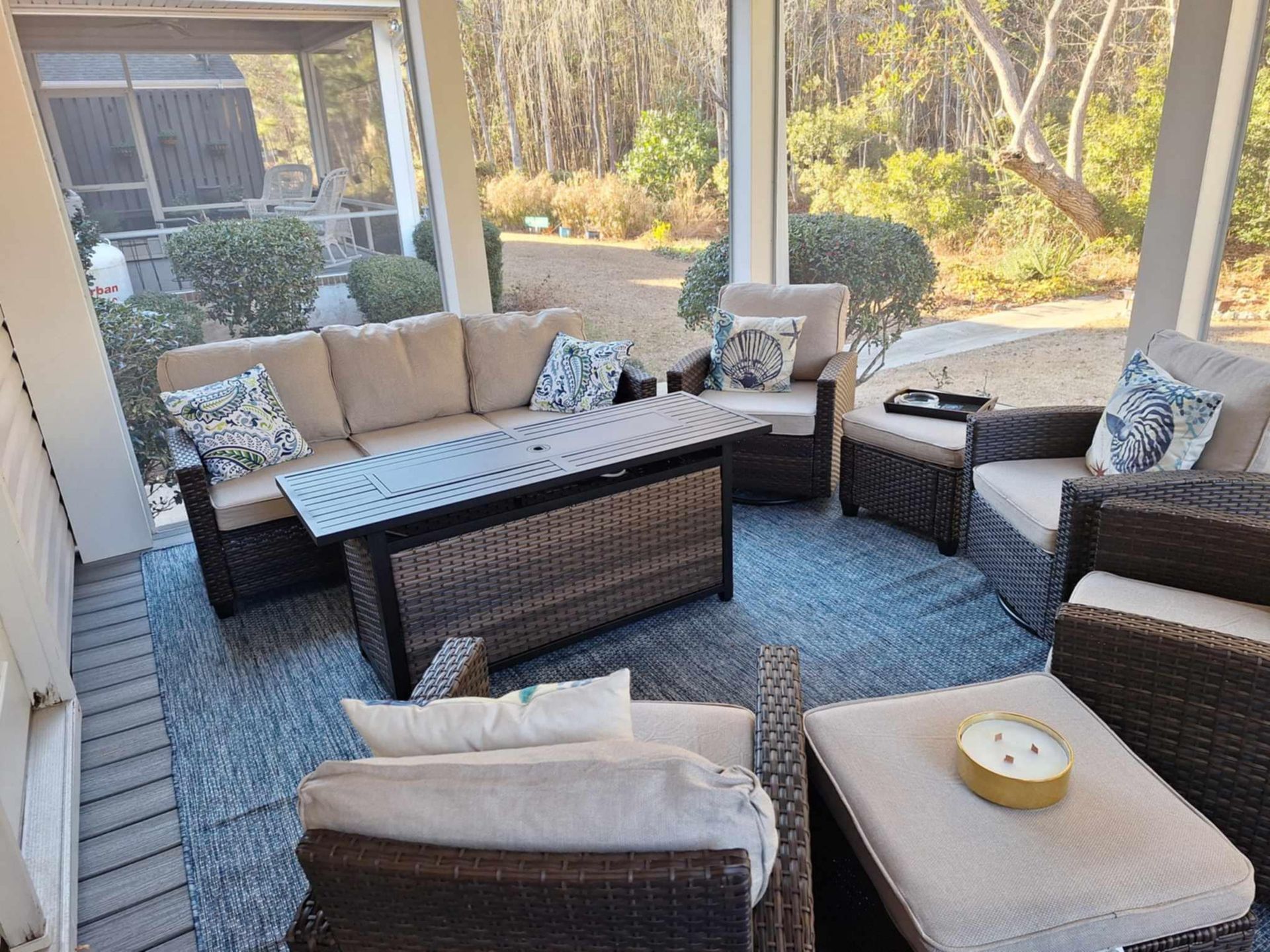 A screened in porch with wicker furniture and a couch.