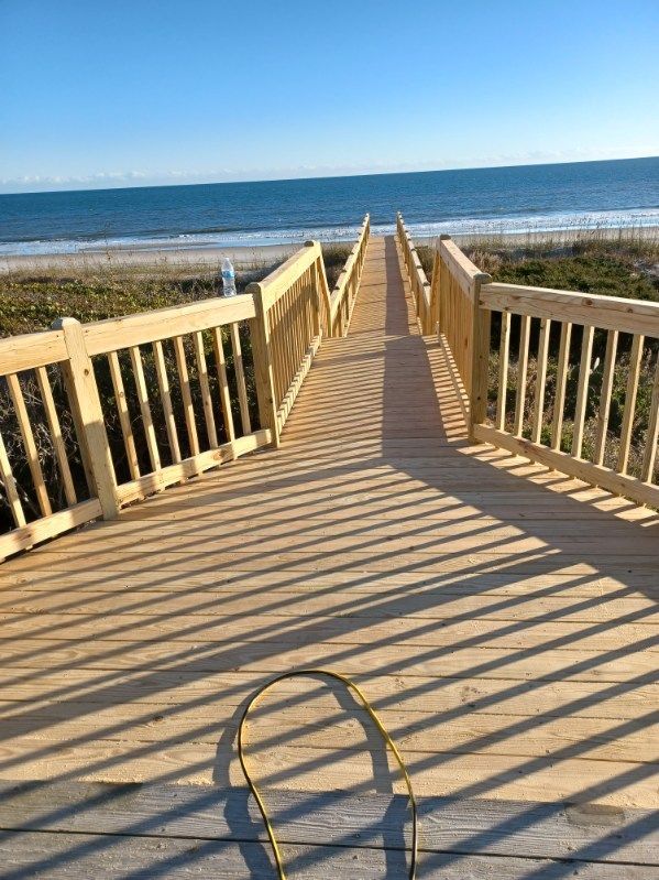 A wooden deck is being built with a white railing.