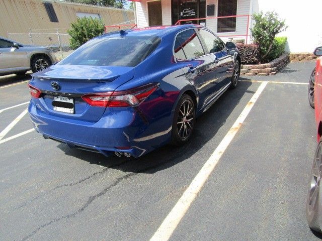 Blue sedan parked in a striped parking space outside a building