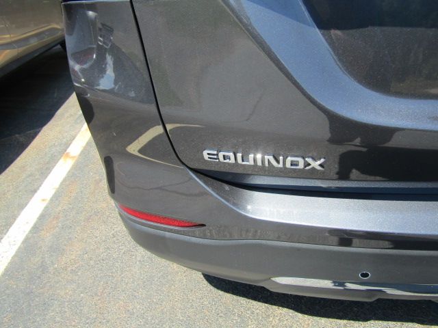Rear of a gray Chevrolet Equinox with a visible bumper scratch in a parking lot