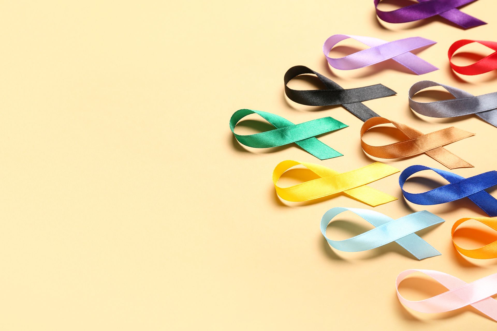 Colorful ribbon bows arranged on a pale beige background