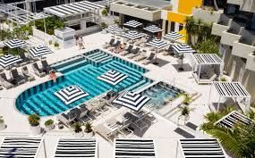 An aerial view of a large swimming pool surrounded by chairs and umbrellas.