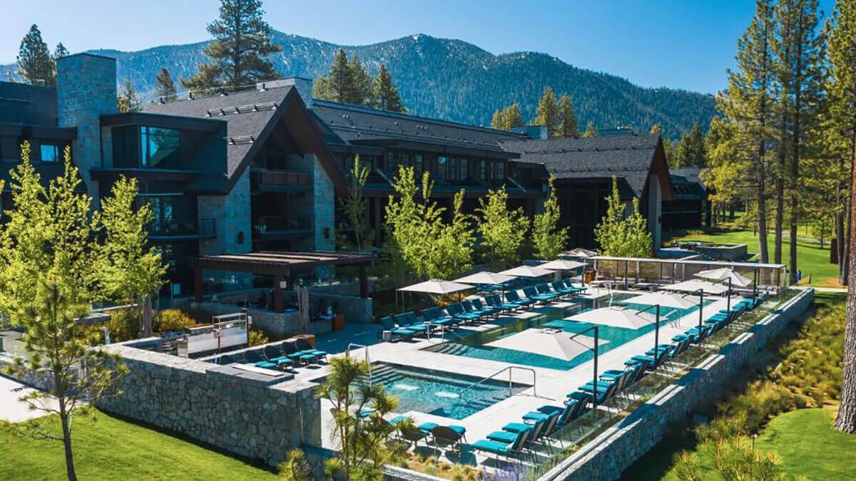 A large building with a large swimming pool in front of it.