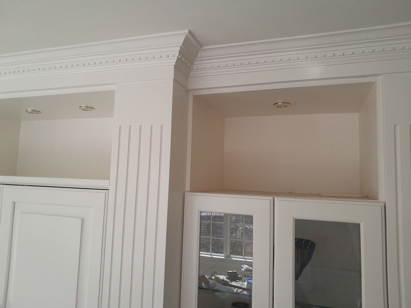 A room with white cabinets and a mirrored door.
