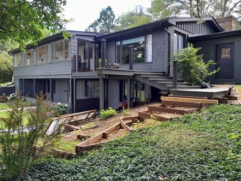 A large house is sitting on top of a lush green hillside.