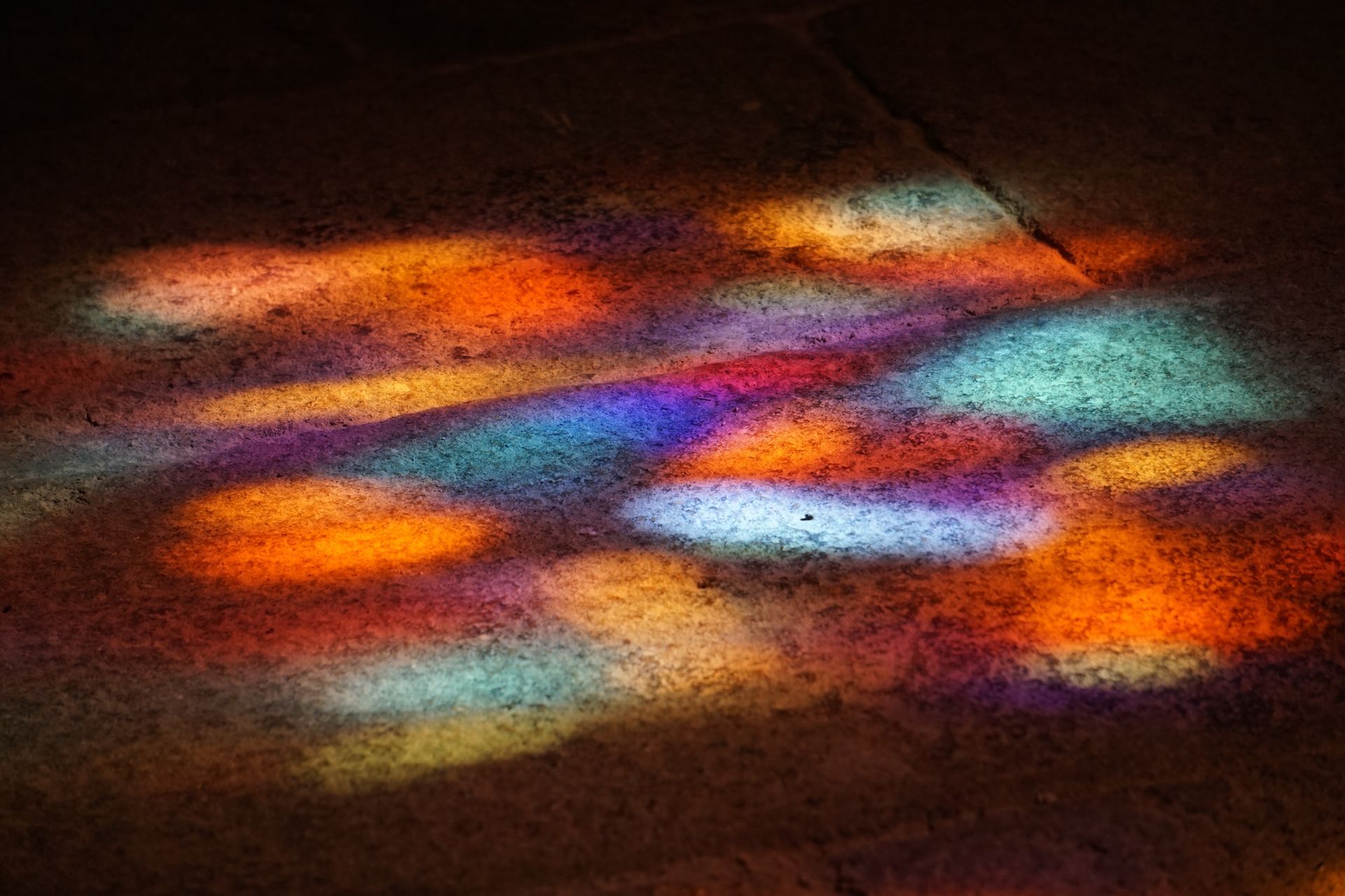Abstract streaks of orange, blue, and red light on a dark surface