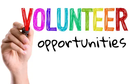 Hand holding marker beside colorful “VOLUNTEER opportunities” text on white background