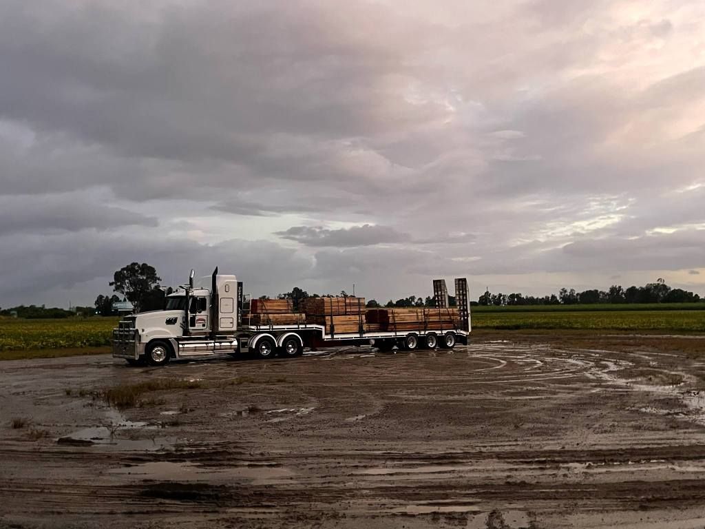 Semi-Truck with Trailer on Muddy Field Under a Cloudy Sky — Rainbow and Sons Heavy Haulage in Wells Crossing, NSW