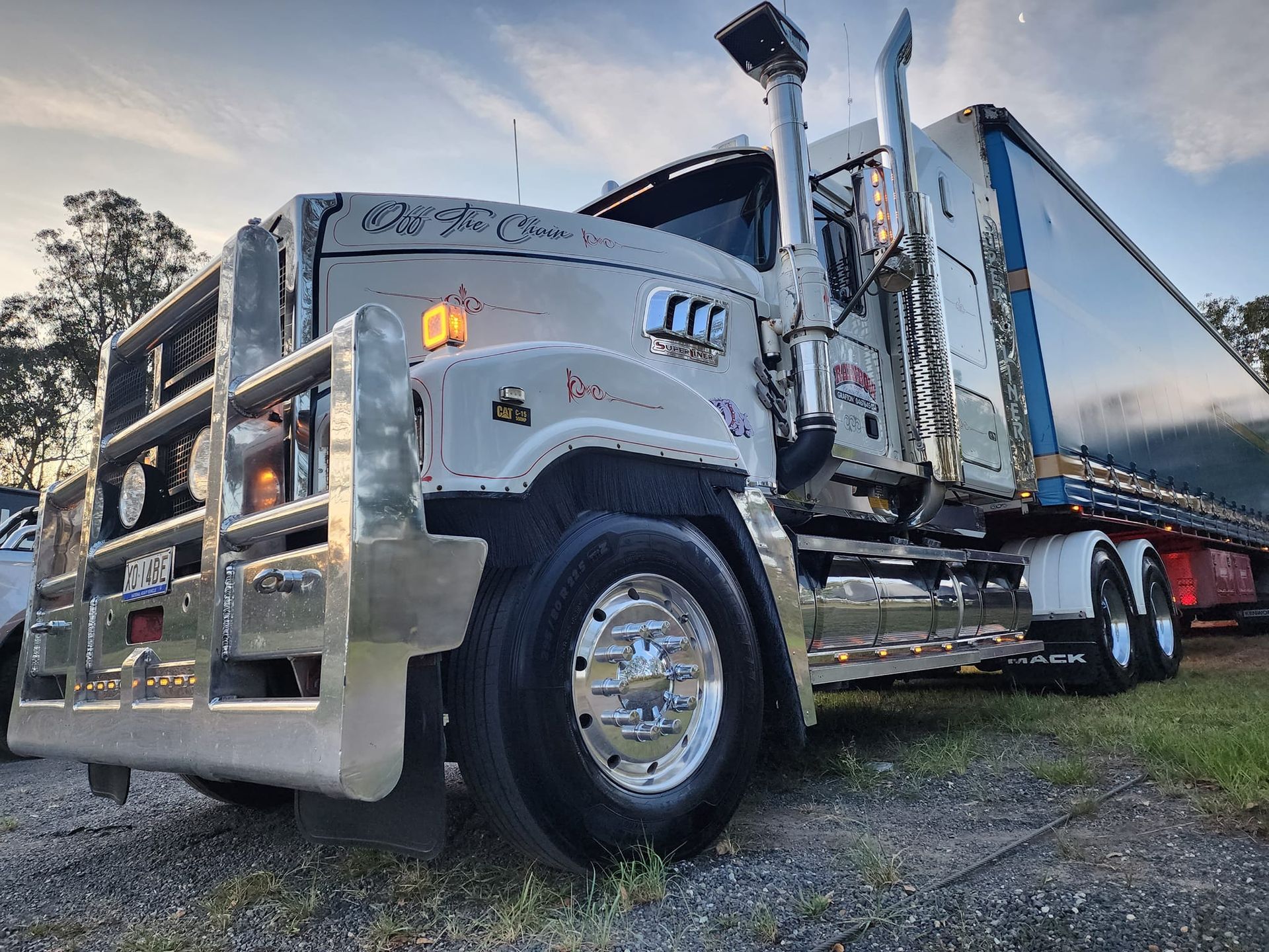 White Semi-Truck with Chrome Grille and Flatbed Trailer — Rainbow and Sons Heavy Haulage in Wells Crossing, NSW