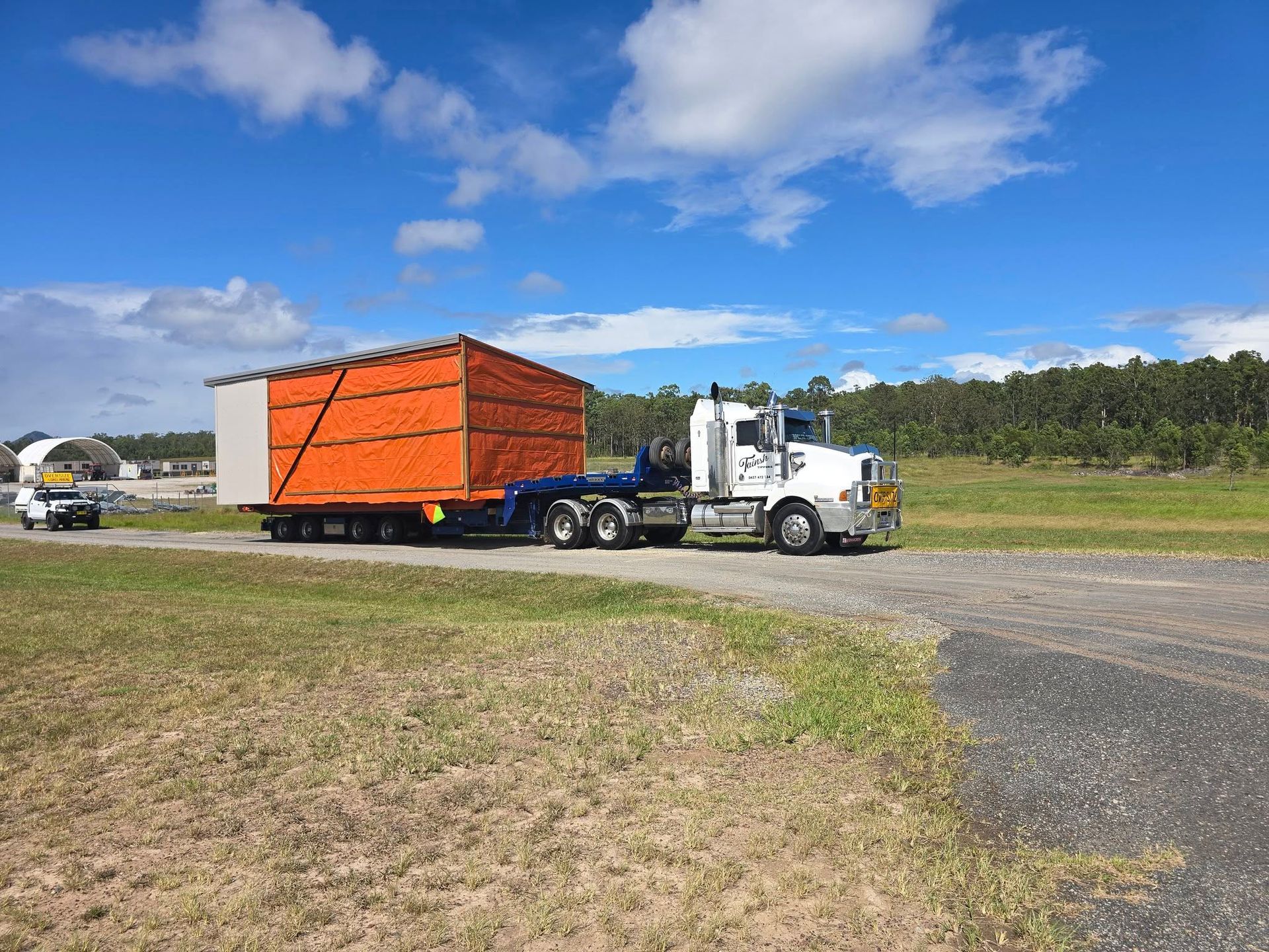 White Semi-Truck Hauling an Orange Cargo Container — Rainbow and Sons Heavy Haulage in Wells Crossing, NSW