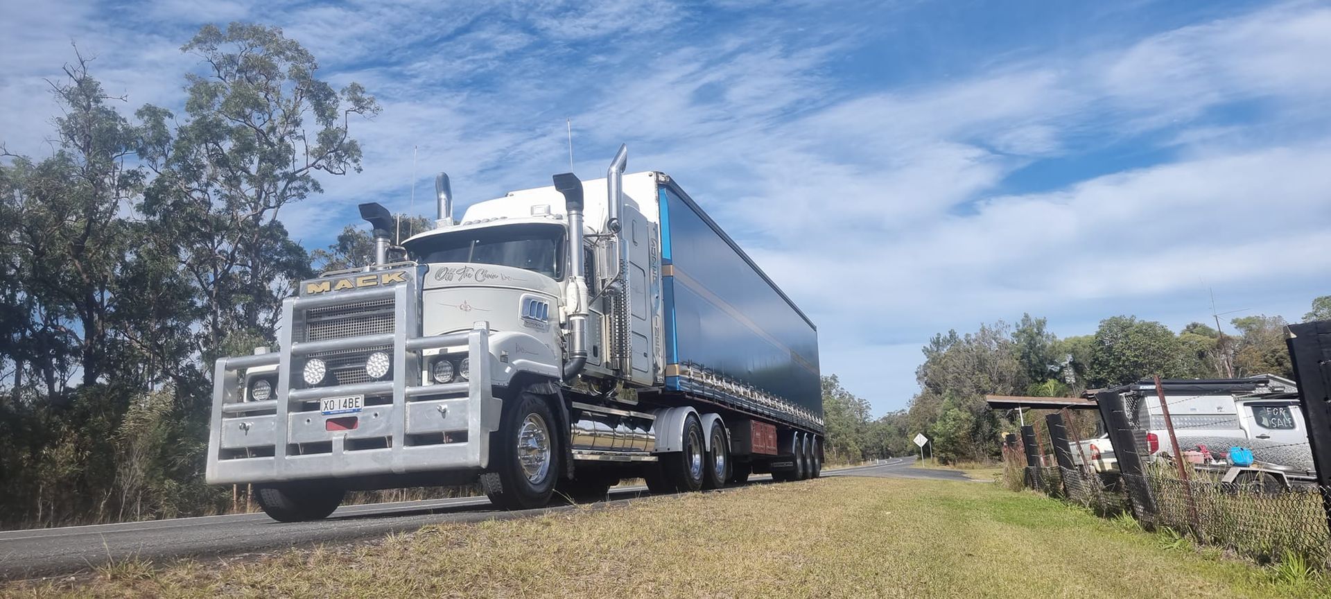 White Semi-Truck Hauling a Trailer on A Grassy Roadside — Rainbow and Sons Heavy Haulage in Wells Crossing, NSW