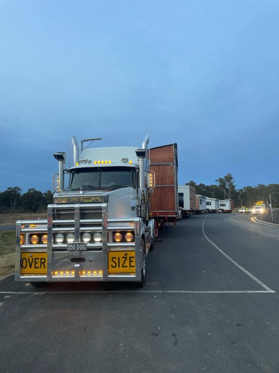 Truck Parked on Roadside at Dusk, With Oversized-load Signs and a Container Trailer— Rainbow and Sons Heavy Haulage in Coffs Harbour, NSW