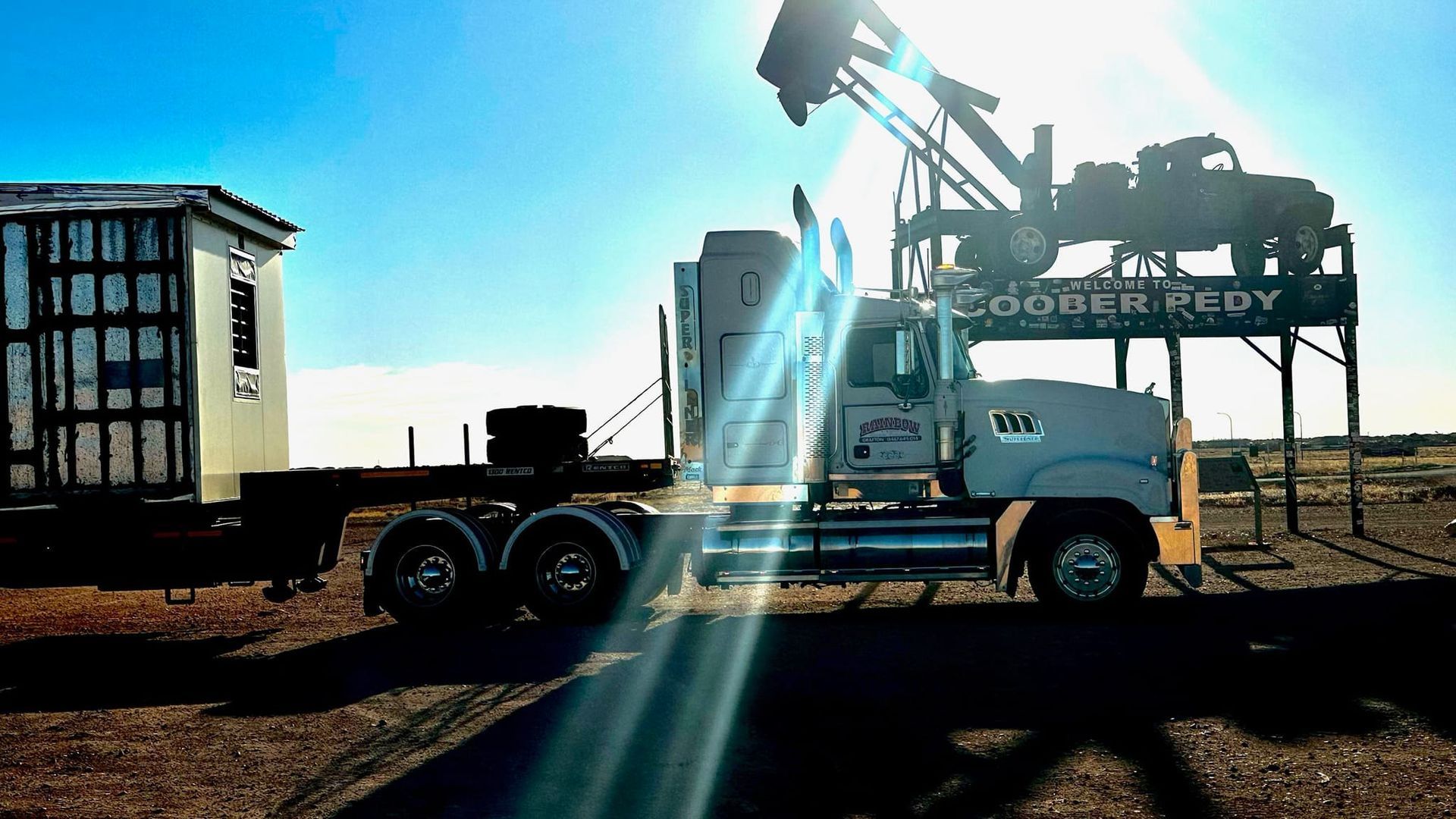 White Truck with Mounted Equipment in A Sunlit Industrial Yard — Rainbow and Sons Heavy Haulage in Coffs Harbour, NSW