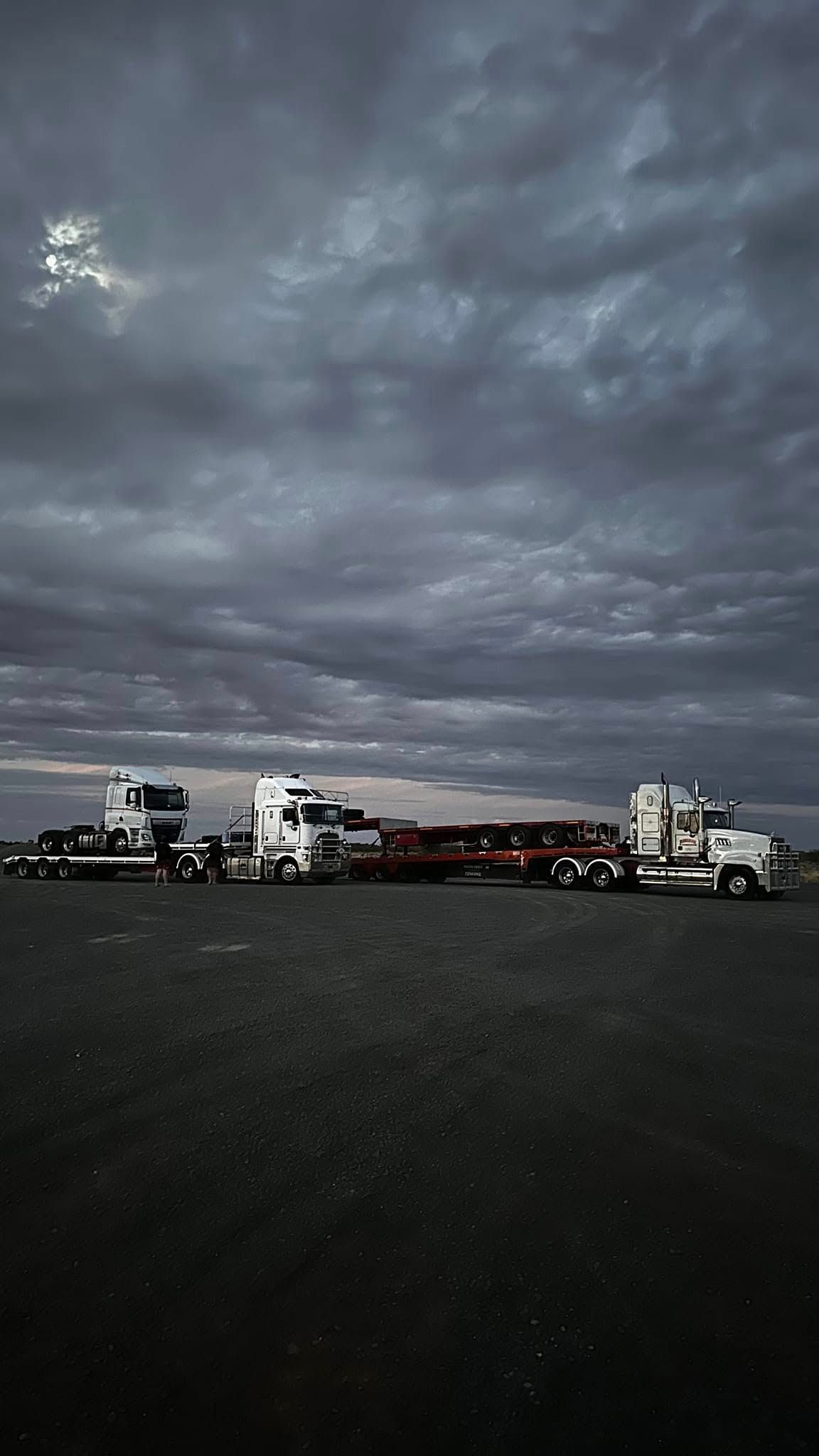 Cloudy Sky Over a Dark Industrial Shoreline — Rainbow and Sons Heavy Haulage in Coffs Harbour, NSW