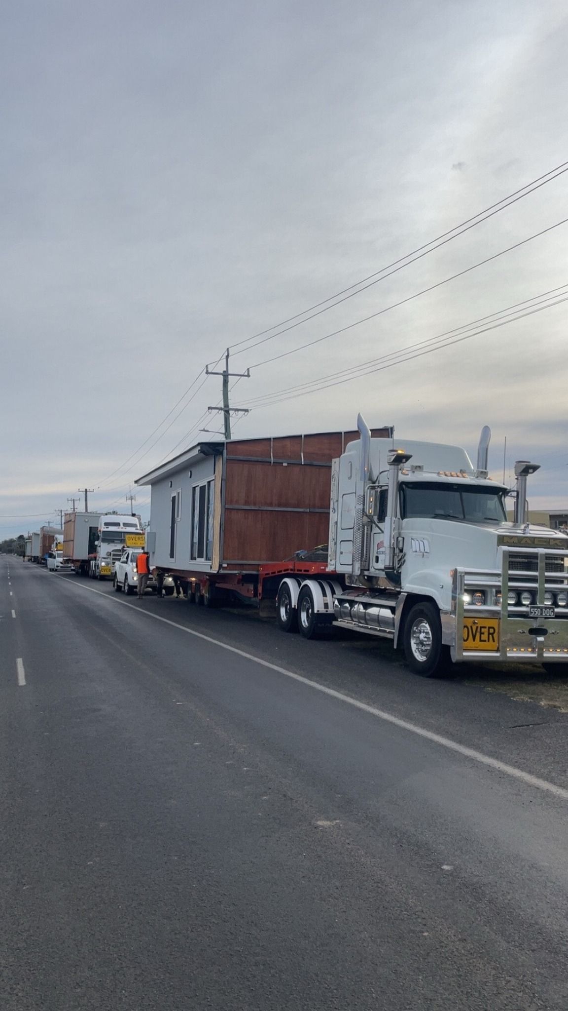 Large White Truck Hauling a Brown Container on A Roadside — Rainbow and Sons Heavy Haulage in Wells Crossing, NSW