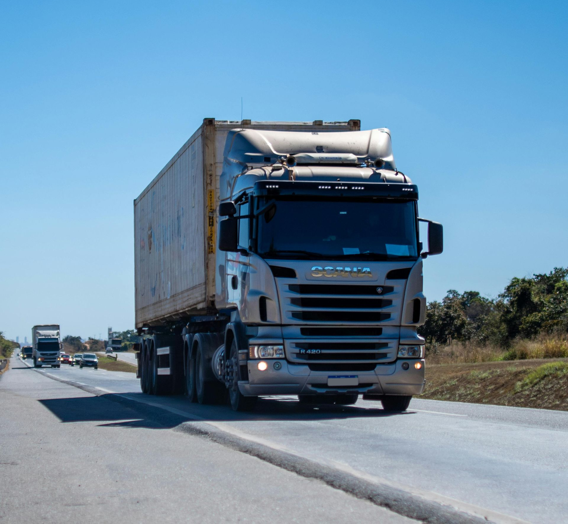 White semi-truck driving on a highway under a clear blue sky — Rainbow and Sons Heavy Haulage in Wells Crossing, NSW