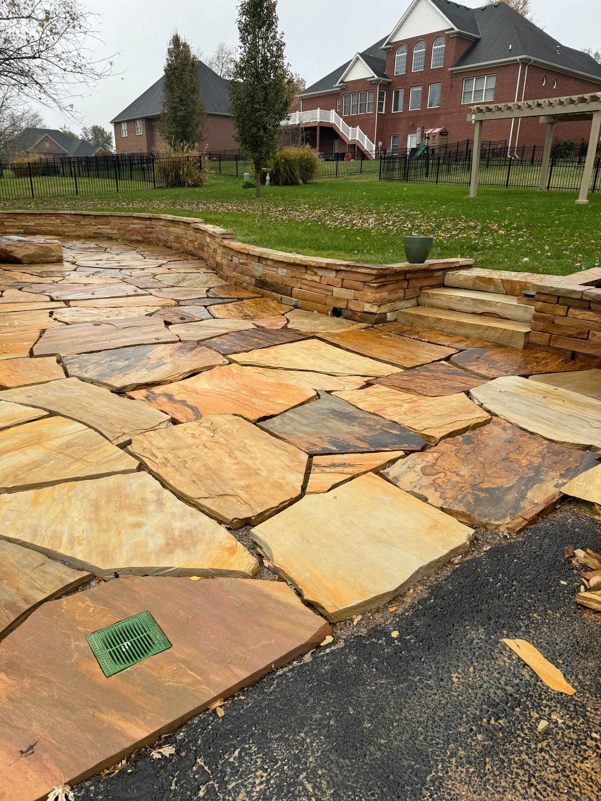 A large stone patio in front of a large house.