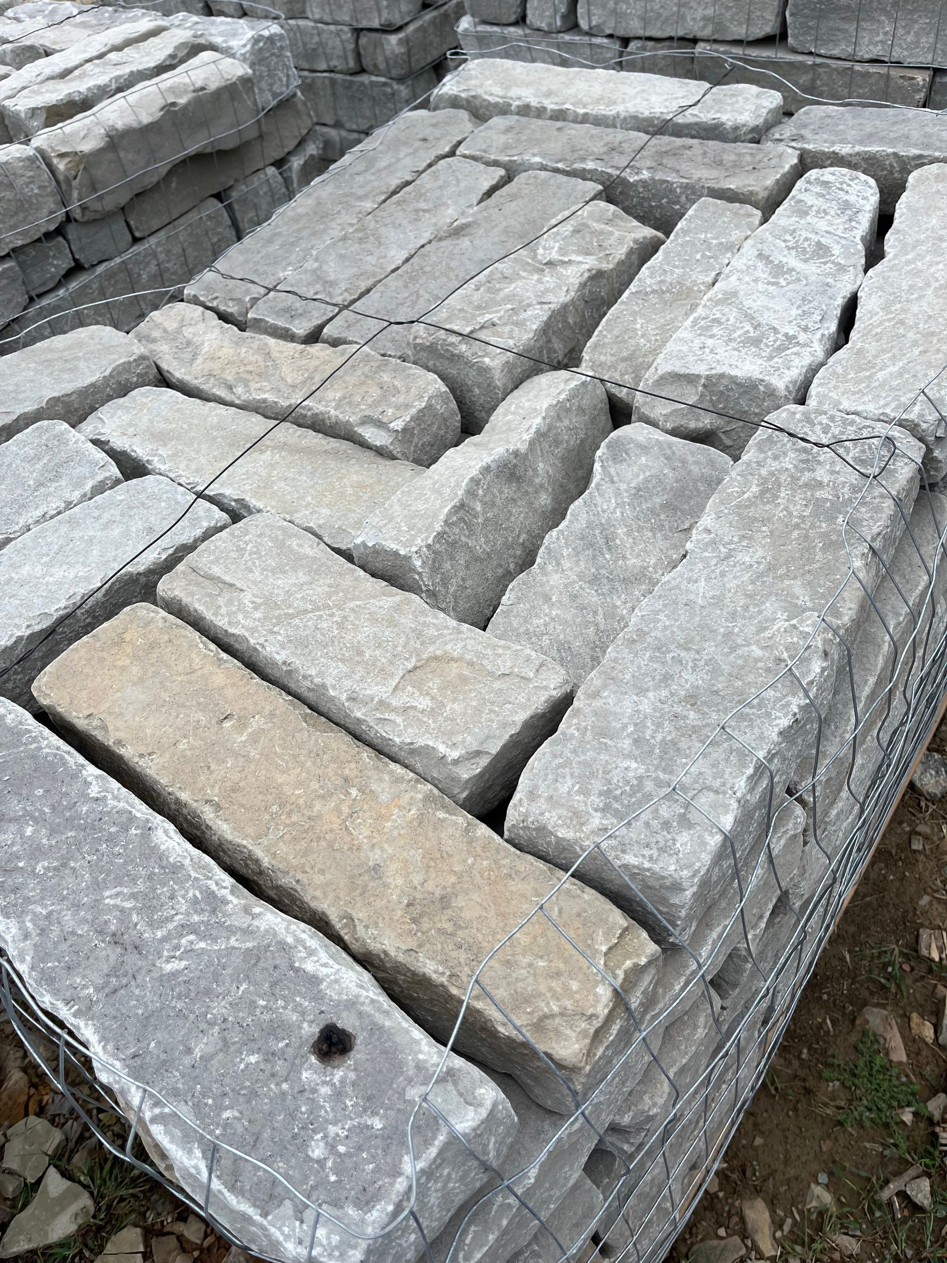 A pile of bricks sitting on top of each other on the ground.