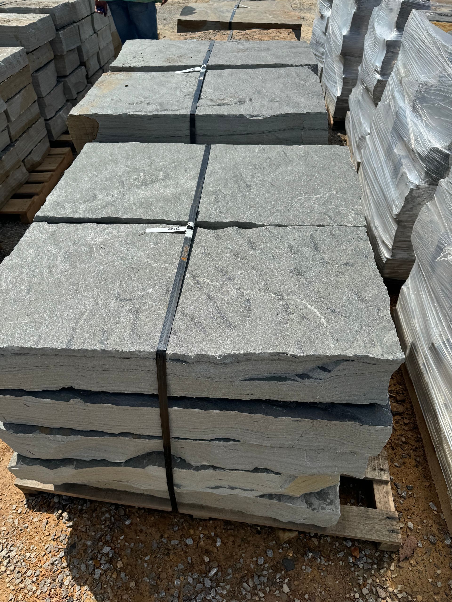 A pile of concrete tiles sitting on top of a wooden pallet.