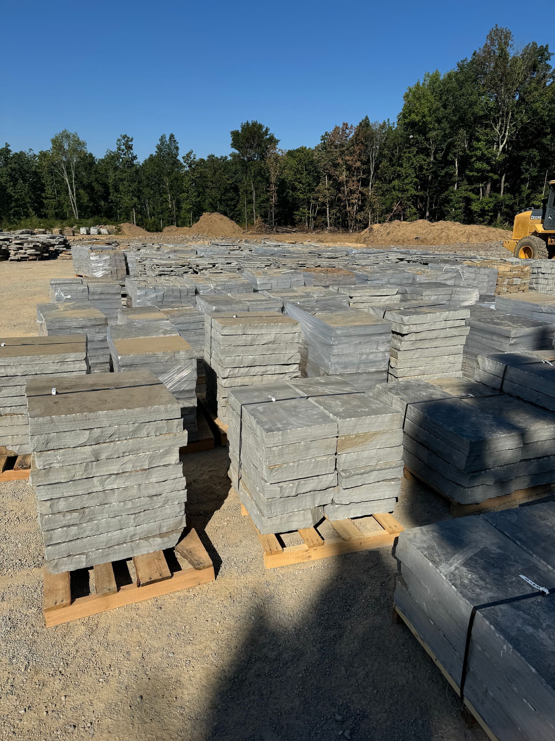 A lot of bricks are stacked on top of each other on a construction site.