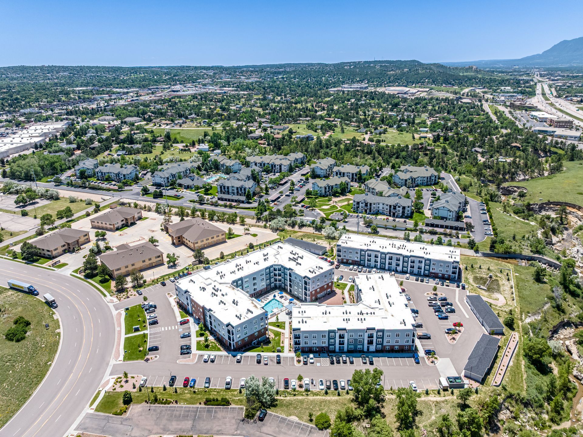 Aerial view of a blue-and-white office complex with parking lots and surrounding neighborhoods