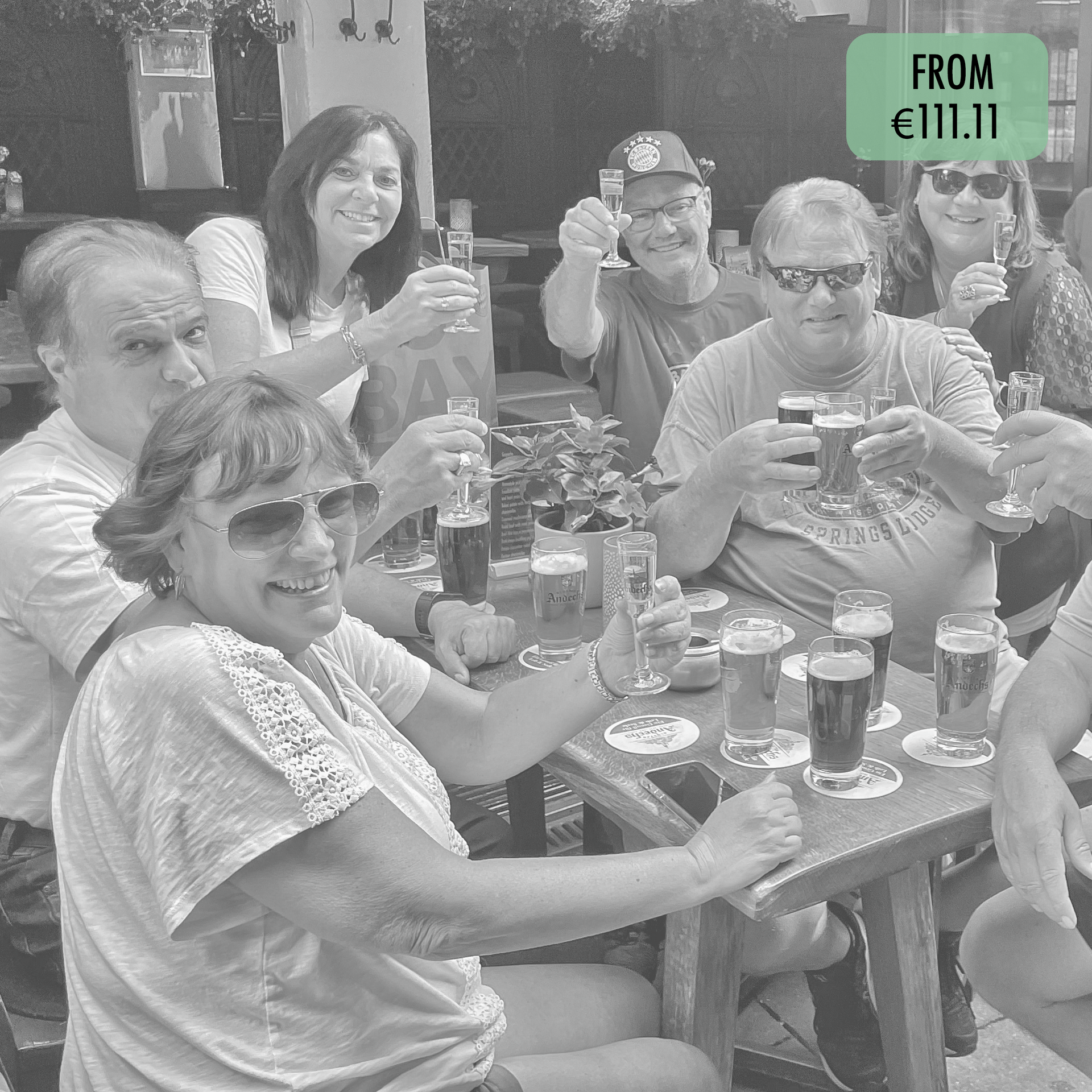 A group of people are sitting at a table drinking beer
