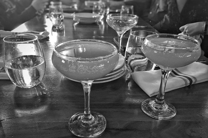 A black and white photo of a table with glasses and plates on it.