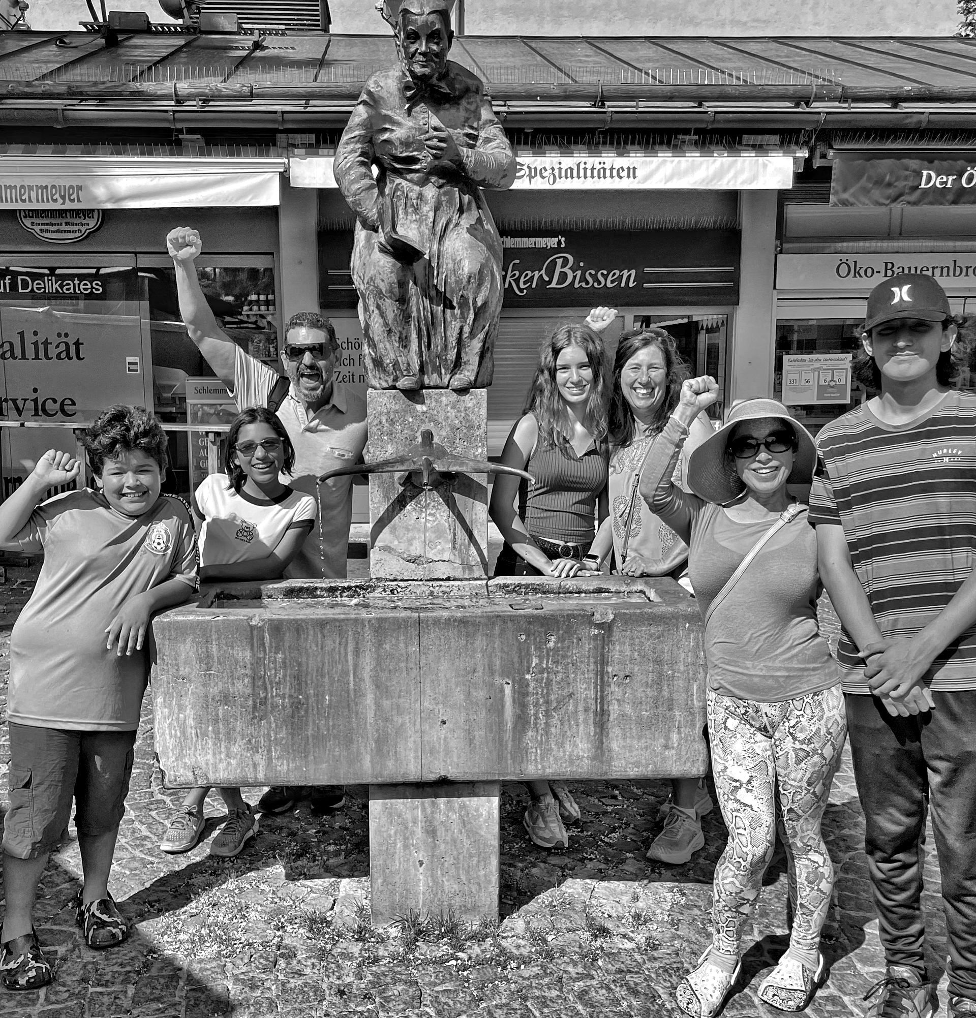 A group of people are posing for a picture in front of a statue.