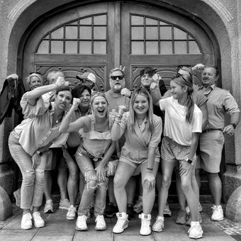 A group of people are posing for a picture in front of a door.