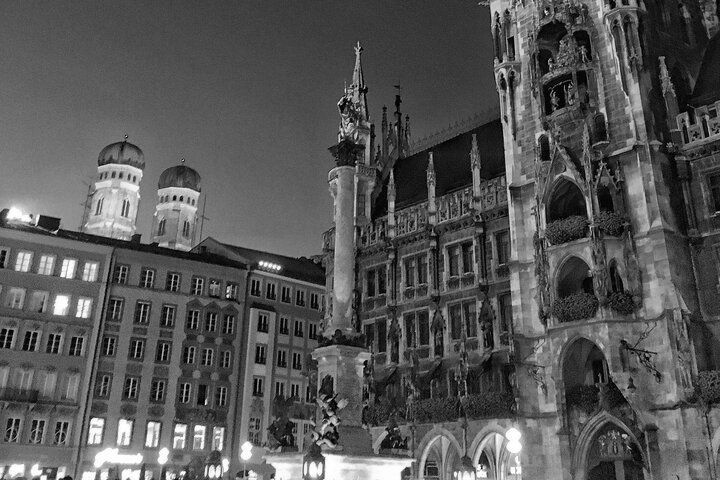 A black and white photo of a city at night with a large building in the foreground.