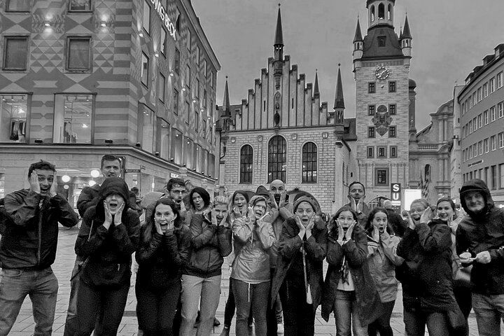 A group of people are standing in front of a building in a black and white photo.