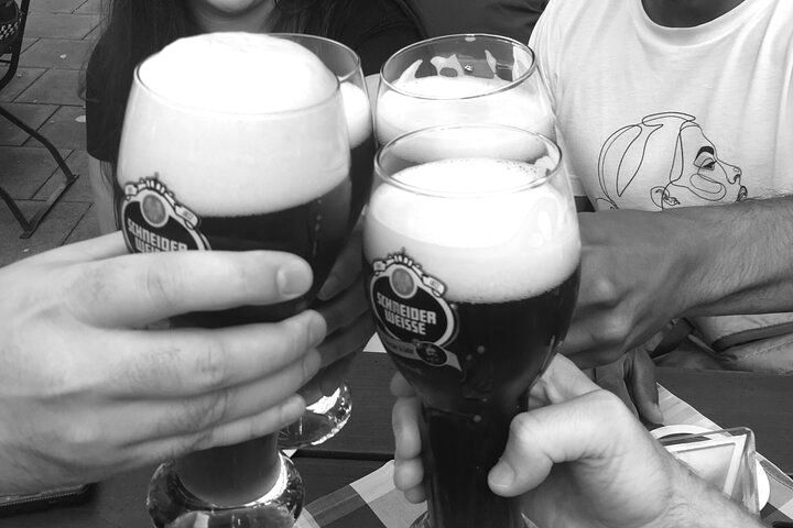 A black and white photo of people toasting with glasses of beer
