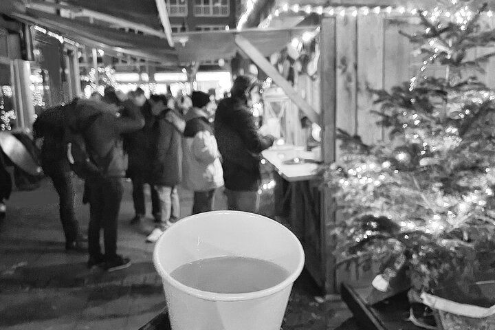 A cup of coffee is sitting on a table in front of a christmas tree.