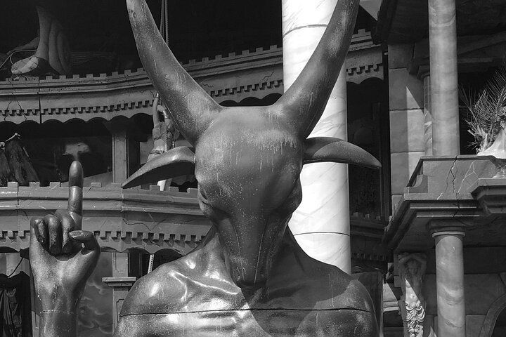 A black and white photo of a statue of a devil with horns.
