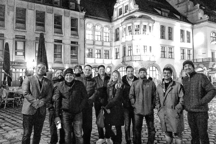 A group of people standing in front of a building at night
