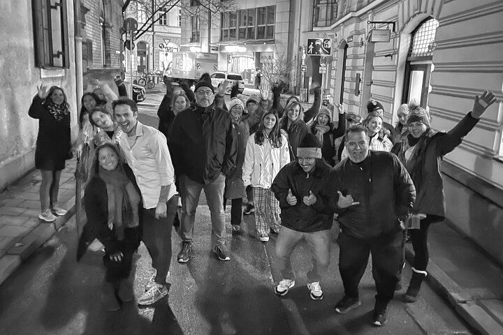 A black and white photo of a group of people standing on a sidewalk.