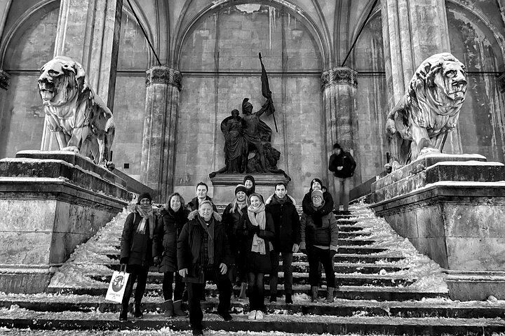 A group of people are standing on a set of stairs in front of a building.