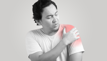 A man is holding his shoulder in pain.