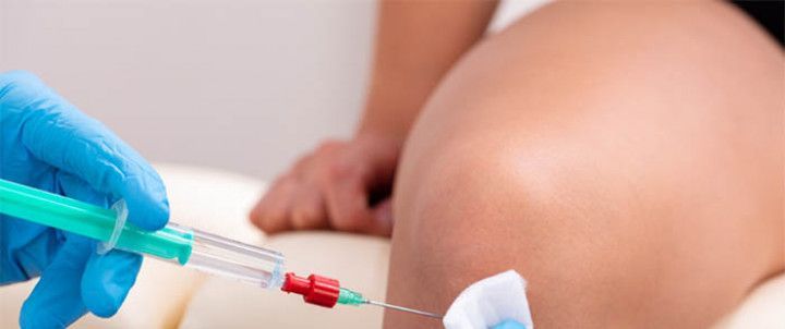 A person is getting an injection in their knee.
